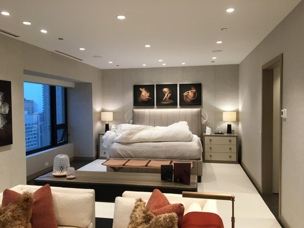A bedroom with a large bed and two lamps