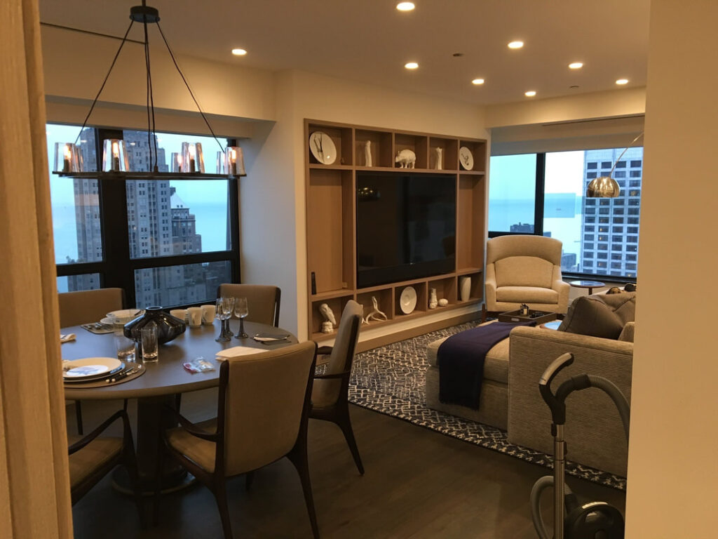 A living room with a table and chairs, tv on the wall