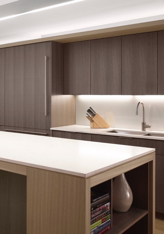 A kitchen with a sink, counter and cabinets.