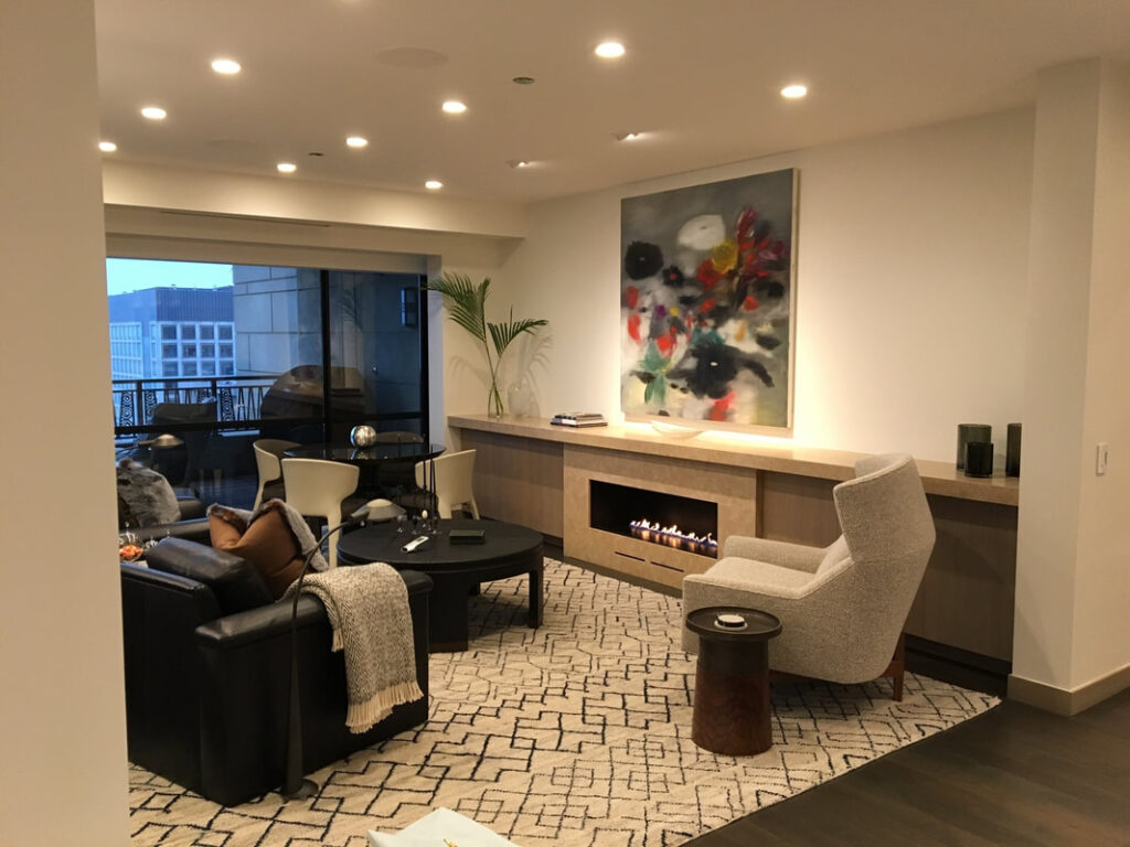 A living room with a fireplace and a large window.