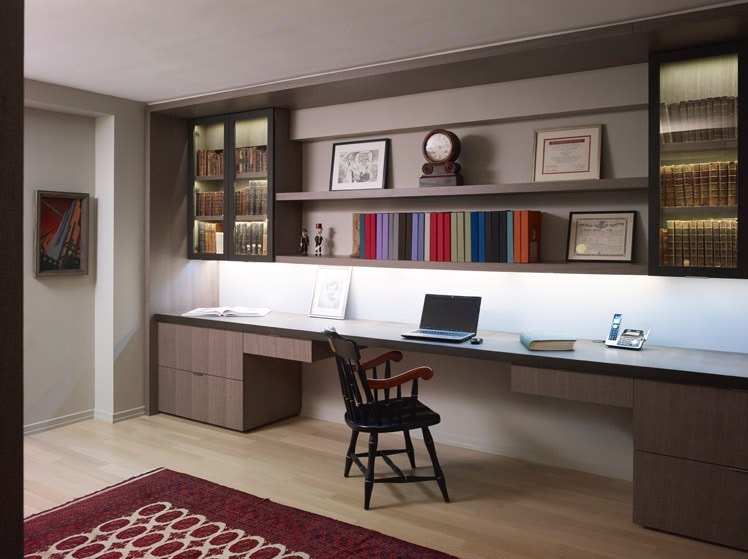 A desk with a laptop and chair in front of it.