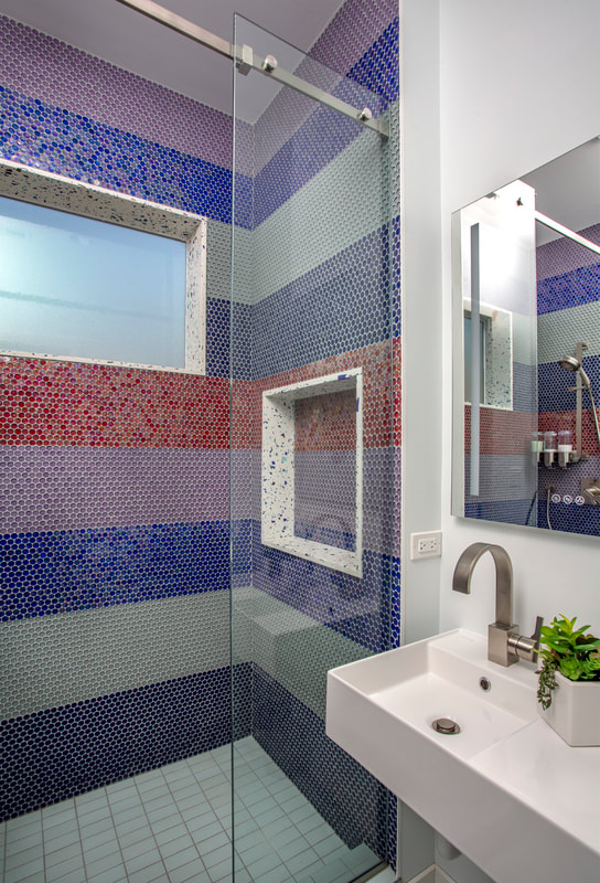 A bathroom with a sink, mirror and shower.