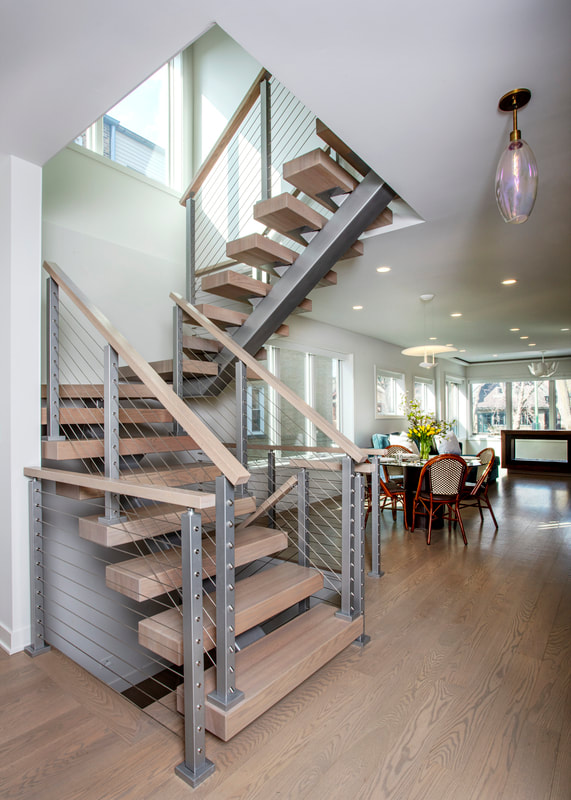 A staircase with metal and wood railing in the middle of it.