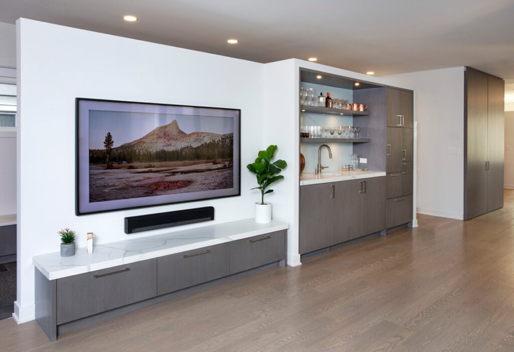 A flat screen tv mounted to the wall in front of a white wall.