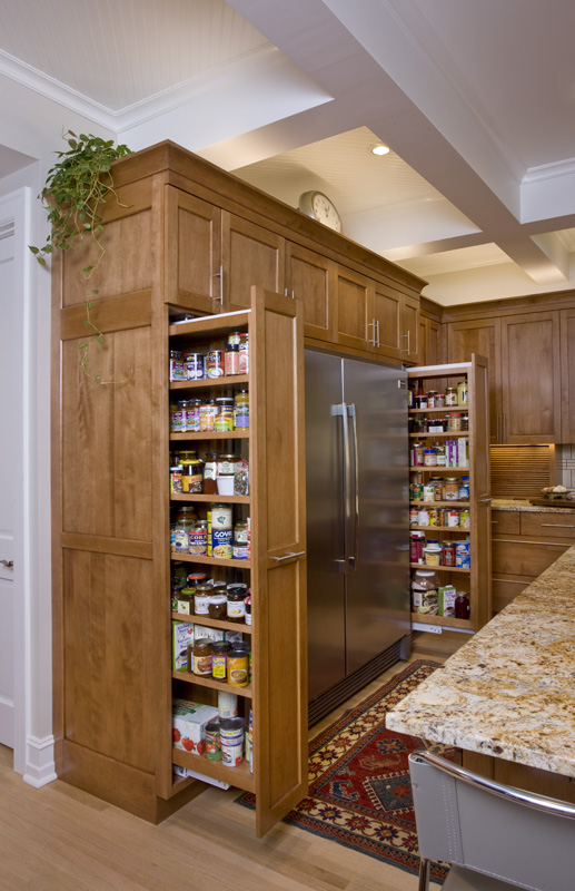 A kitchen with wooden cabinets and shelves filled with food.