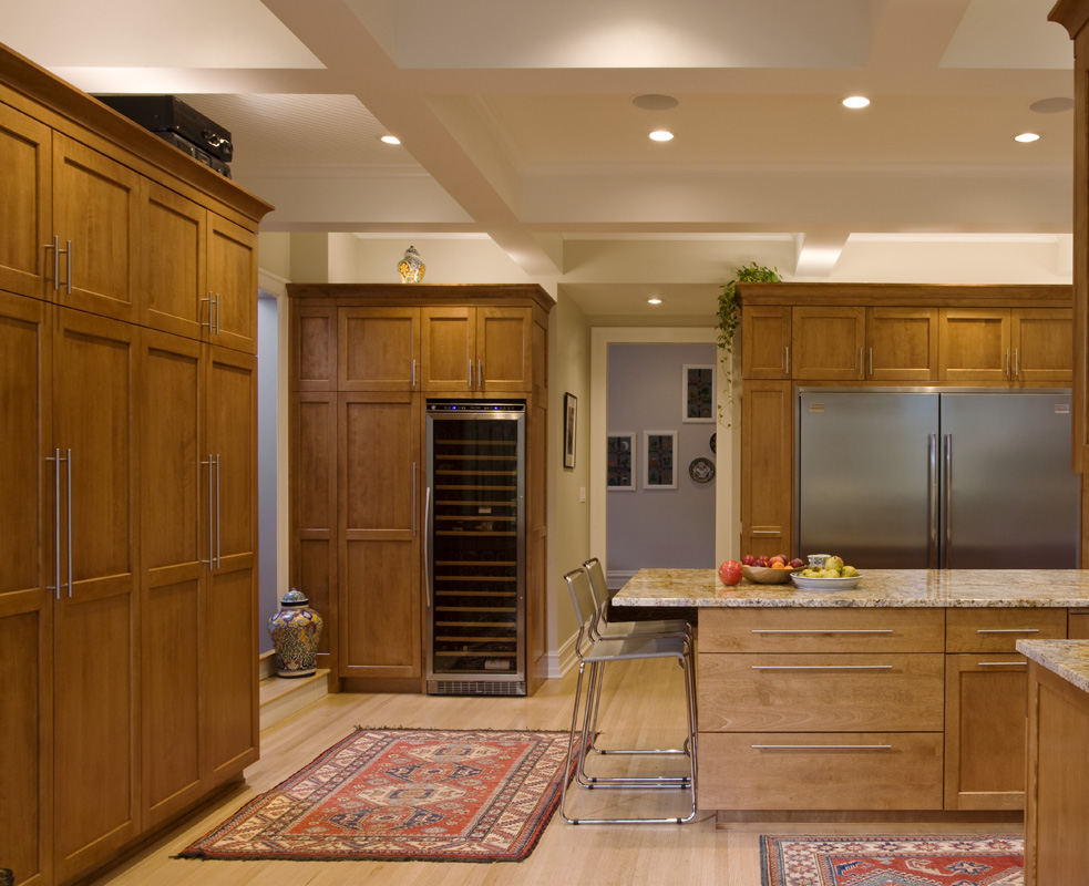 A kitchen with wooden cabinets and a wine cooler.