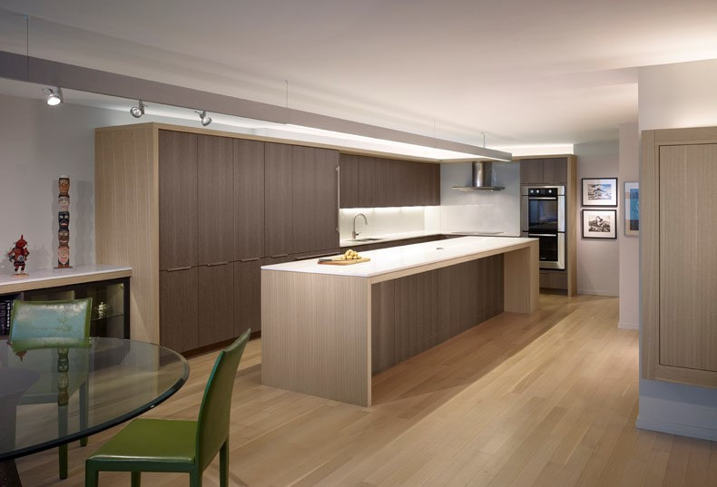 A kitchen with wooden floors and white cabinets.