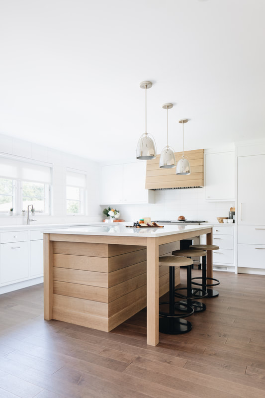 A kitchen with white walls and wooden cabinets.