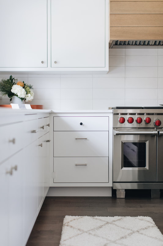 A kitchen with white cabinets and stainless steel appliances.