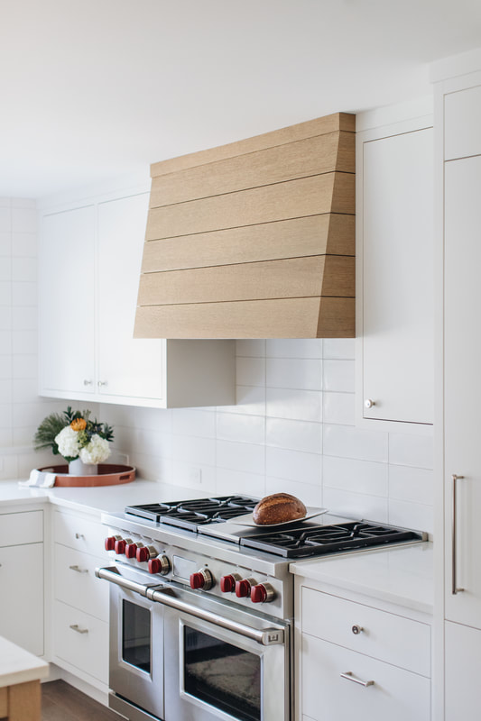 A kitchen with white cabinets and a stove.